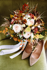 Wedding accessories. bride's shoes, wedding rings, boutonniere on a chair