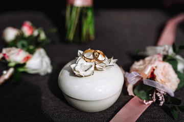 Wedding accessories. bride's shoes, wedding rings, boutonniere on a chair