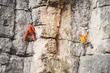 Man and woman climb a rock. 
