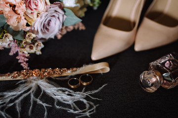 Wedding accessories. bride's shoes, wedding rings, boutonniere on a chair