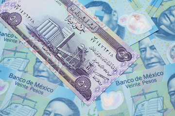 A purple Iraqi fifty dinar bank note close up in macro with an assortment of Mexican twenty peso bank notes 