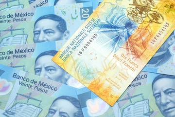 Fototapeta premium A yellow, ten Swiss franc note from Switzerland close up in macro with Mexican twenty peso bank notes