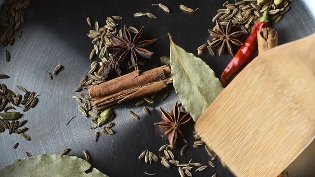 Tossing an assortment of herbs and spices in a pot in preparation for cooking the dinner viewed in close up from aboveNeues Projekt 1