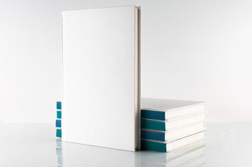 Book with blank cover on reflective surface and white background