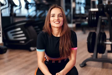 Rolgordijnen Woman fitness trainer portrait on a gym background © fotofabrika