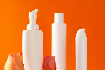 Cosmetic bottles with rose petals, copy space