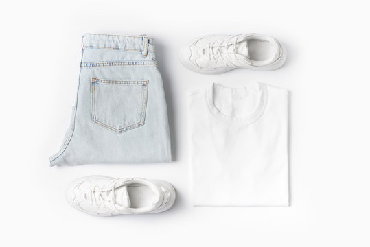 Fashion Female Clothes On White Background. Basic T Shirt And Denim Jeans And Sneakers.