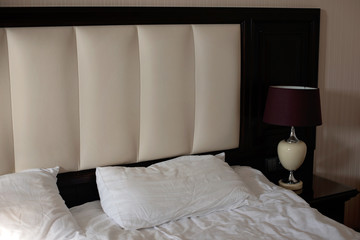The interior of the bedroom in a classic style. Bed with nightstand and floor lamp. Hotel room....