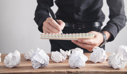 Businessman writing on notepad in business desk.