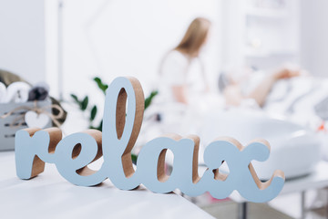 inscription: relax on the blurred background of the spa salon where the doctor performs a cosmetic...