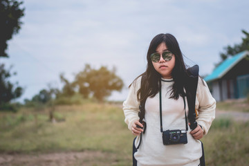 Naklejka premium Asian women traveling alone with backpack and camera.Travel Holiday Relaxation Concept , Vintage Style.