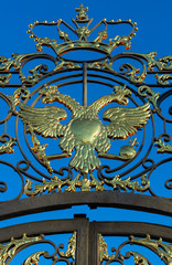 Glittering golden double-headed eagle - the coat of arms of Russian Empire on the lattice of the Catherine Palace vertical orientation (Tsarskoye Selo, Saint Petersburg, Russia)
