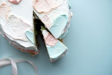 Birthday cake with a slice cut off on blue background Photo