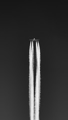 Airplane flying with a black background and leaving contrails and vapour