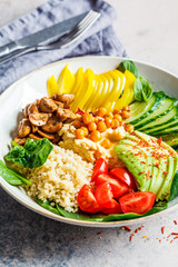 Vegan lunch bowl with quinoa, hummus, chickpeas, avocado, vegetables and mushrooms.