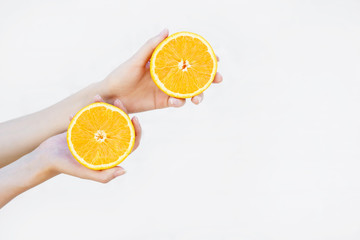 women's hands hold a juicy half orange isolated on white background. Nutrition concept, health, charge of vitamins.place for text.