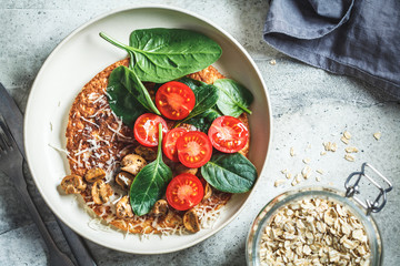 Oatmeal omelet pancake with cheese, mushrooms, tomatoes and spinach. Healthy fitness breakfast.
