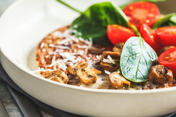 Oatmeal omelet pancake with cheese, mushrooms, tomatoes and spinach. Healthy fitness breakfast.