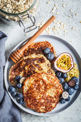 Oatmeal pancakes with honey, fruits and berries, top view. Healthy vegan food concept.