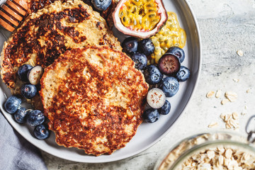 Oatmeal pancakes with honey, fruits and berries, top view. Healthy vegan food concept.