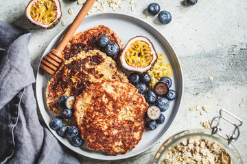 Oatmeal pancakes with honey, fruits and berries, top view. Healthy vegan food concept.
