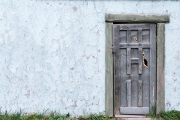 Background of an old wall with a door and peeling plaster, copy space.