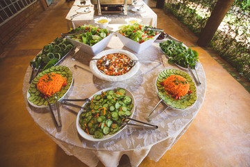 salad table with arugula, cucumber, carrot and vinaigrette 