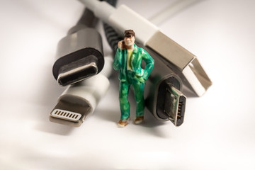 Obraz na płótnie Canvas Miniature Guy standing next to different Plugs