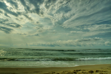 Beautiful sunset over sea with reflection in water, majestic clouds in the sky