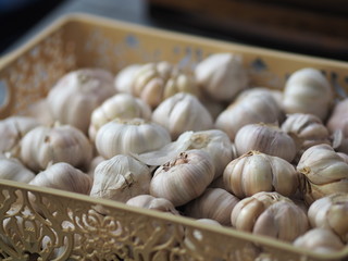 Garlic in a bunch, placed in a brown plastic basket