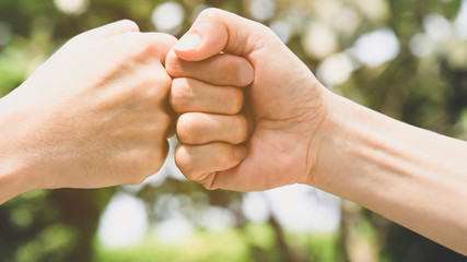Teamwork in the nature concept,Which Young man fist bump  in the nature of bokeh background,