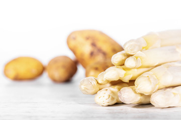 lot of fresh brown potatoes and white asparagus
