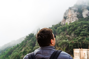 Naklejka premium Back view of man on hiking trail. Backpacker traveling. 