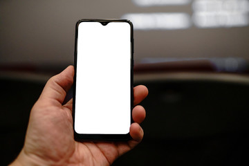 man uses a smartphone in a movie theater