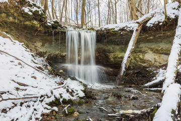 City Sigulda, Latvia. Waterfall in winter. White snow and trees. Travel photo.