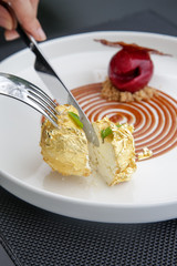 Beautiful elegant dessert in a plate. Exquisite dish with gold flakes, creative restaurant pastry concept, haute couture food
