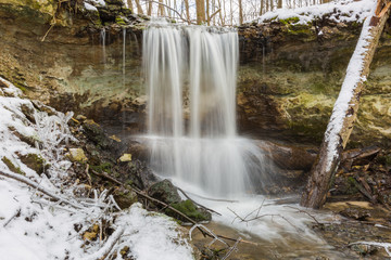 City Sigulda, Latvia. Waterfall in winter. White snow and trees. Travel photo.