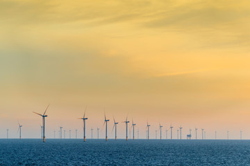 HORNSEA OFFSHORE WIND FARM, UK - 2016 JULY 15. The sun sets behind a coastal wind farm at Hornsea.