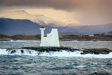 KVITHOLMEN LIGHTHOUSE, NORWAY - 2016 DECEMBER 01. Sunlights on the mountain behind the Lighthouse...