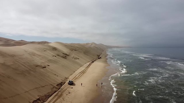Aerial shot of the Sandwich Harbour massive sand dunes on the shore of the ocean