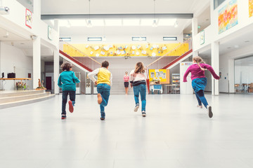 Students running to their classes in school main hall