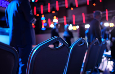 Empty chairs in the first row at conference before the event