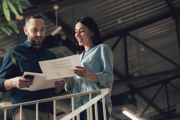 Mirthful lady showing documents to colleague stock photo