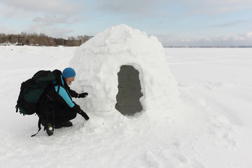 Man in warm clothes at the entrance to the igloo in winter Novosibirsk, Russia