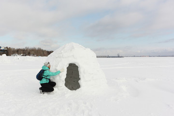 Happy woman building an igloo on a snow glade in the winter,  Novosibirsk, Russia