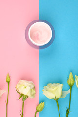 Roses and cream. on a pink-blue background. open and closed buds, place for an inscription. flat lay.