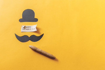 Father's day concept. funny moustache with hat and cigar on yellow background. flat lay, top view.