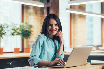 Mirthful employee with laptop at work stock photo