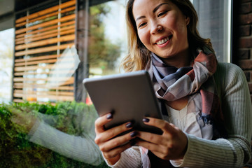 Close up of a Beautiful Asian woman looking at her tablet	