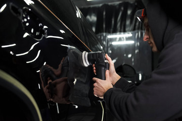 Auto polishing process. Detailing worker polishes car body